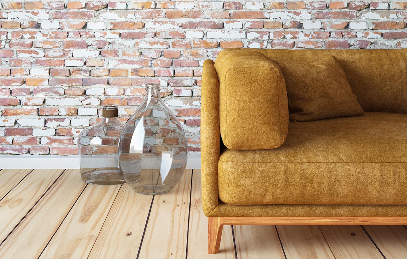Couch auf einem Holzdielenboden vor einer Backsteinwand